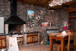 uma cozinha com um fogão e uma parede de pedra em AYAR - Portentos & Cabañas QHAPAQ em Virú