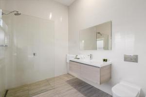 a white bathroom with a sink and a shower at House on Grosvenor in Sandy Bay