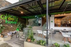 a restaurant with tables and chairs in front of a building at Lleras Green Hotel in Medellín