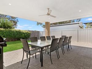a dining table and chairs on a patio at Estuary Break in Erskine in Mandurah