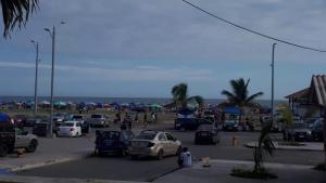 ein Parkplatz mit Autos und Menschen und der Strand in der Unterkunft Apartamento Familiar frente a la Playa in Playas
