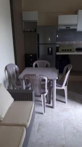 een tafel en stoelen in een kamer met een keuken bij Apartamento Familiar frente a la Playa in Playas