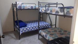 two bunk beds in a small room with a bed at Apartamento Familiar frente a la Playa in Playas