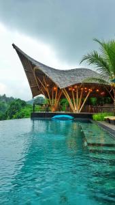 烏布的住宿－Kadewa Retreat Ubud - Adults Only，一座游泳池,上面有一座大型水面建筑