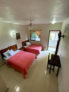 a bedroom with two beds and a table in it at Hotel Santa Isabel in Ciudad del Carmen