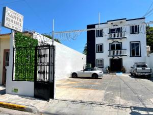 een witte auto geparkeerd voor een wit gebouw bij Hotel Santa Isabel in Ciudad del Carmen