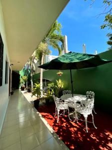 a table and chairs under an umbrella on a patio at Hotel Santa Isabel in Ciudad del Carmen