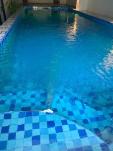 a swimming pool with a blue and white tile floor at Poetic Hue Hotel & Spa in Hue