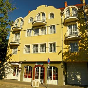 um edifício amarelo com duas varandas em cima em Hotel Wesselényi em Gyor