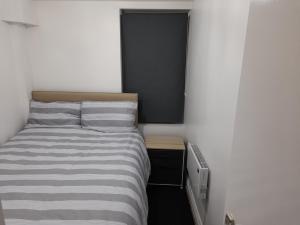um pequeno quarto com uma cama e uma mesa de cabeceira em Zest Apartment Two em Manchester
