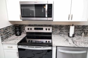 a kitchen with a stove and a microwave at Gorgeous Condo on Golf Course Near Broadway at the Beach in Myrtle Beach