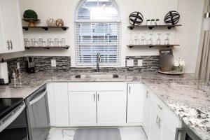 a kitchen with white cabinets and a sink at Gorgeous Condo on Golf Course Near Broadway at the Beach in Myrtle Beach