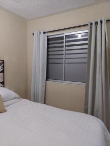 1 dormitorio con cama y ventana en Habitación Privada en RESIDENCIAL Villa de Las Hadas en Tegucigalpa