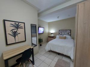 a bedroom with a bed and a desk and a television at Habitación Privada en RESIDENCIAL Villa de Las Hadas in Tegucigalpa