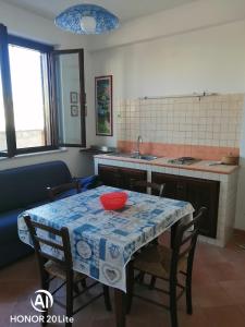 a kitchen with a table and some chairs and a table and a kitchen at casetta in centro paese a 2 passi dalla piazza Matrice in Favignana
