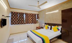 Habitación de hotel con cama y TV en Itsy By Treebo - Aakash, 100 Mts From Sardar Patel Stadium en Ahmedabad