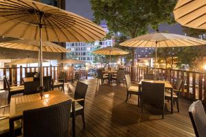 a restaurant with tables and umbrellas on a deck at Golden Seoul Hotel in Seoul