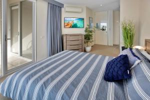 1 dormitorio grande con cama de rayas azul y blanco en Harbour Views en Lakes Entrance
