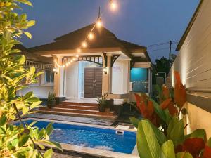 una casa con piscina por la noche con luces en Xent Pool Villa Ranong en Ranong