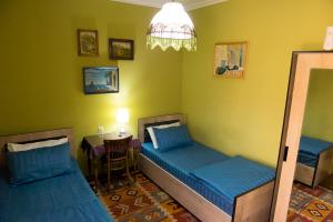 Habitación con 2 camas y mesa con silla. en Old Radio hostel en Samarcanda