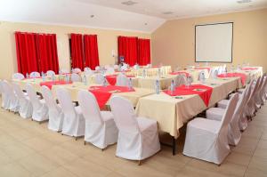 a conference room with tables and chairs and a screen at ACK Resort Salama in Salama