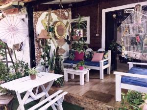 a patio with tables and chairs and bird cages at Casa de Mirtes in Fernando de Noronha