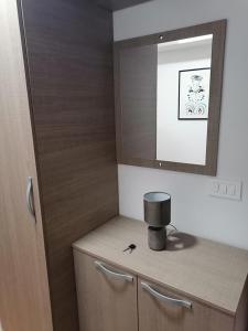 een badkamer met een houten kast en een spiegel bij Cosmopolit Apartments in Ohrid