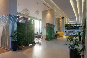 a lobby with a green wall and plants at Avani Ibn Battuta Dubai Hotel in Dubai