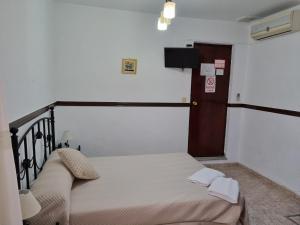 1 dormitorio con 1 cama y puerta pequeña en Pensión Javier en Sevilla