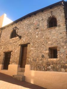 a stone building with four windows on it at casa de piedra.The stone house in Turre