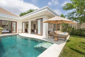 een villa met zwembad en parasol bij Gajah Villas Bali by Nagisa Bali in Seminyak