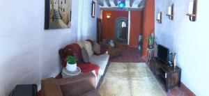 a living room with couches and a tv at casa de piedra.The stone house in Turre