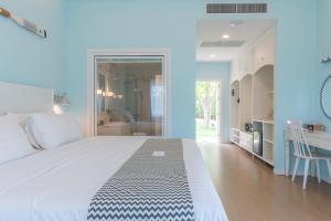 een slaapkamer met een groot bed en een badkamer bij Peggy's Cove Resort in Chao Lao Beach