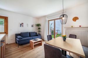 uma sala de estar com um sofá azul e uma mesa em Haus Hohenrain Ferienwohnung 2 em Scena