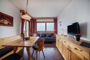 een woonkamer met een bank, een tafel en een tv bij Haus Hohenrain Ferienwohnung 4 in Schenna