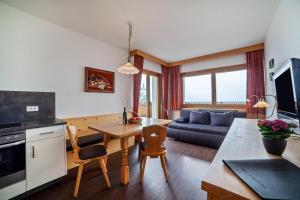 シェーナにあるHaus Hohenrain Ferienwohnung 4のキッチンとテーブルとソファのあるリビングルーム