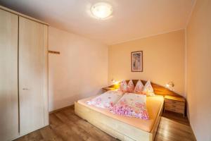sypialnia z dużym łóżkiem z różowymi poduszkami w obiekcie Ferienwohnung Hirzer w mieście Saltusio