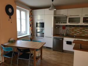 uma cozinha com uma mesa de madeira e cadeiras azuis em Ubytování Husova 842 em Turnov