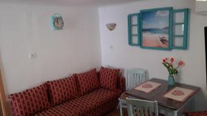 a living room with a red couch and a table at Apartman Manuela in Baška