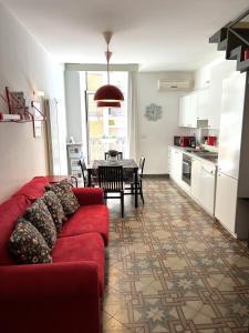 salon z czerwoną kanapą i kuchnią w obiekcie Bienvenue 3 w mieście Bari +24 zdjęcia