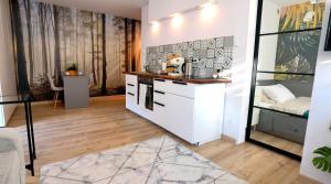 a kitchen with white cabinets and a counter at Apartament Sosnowa in Puławy