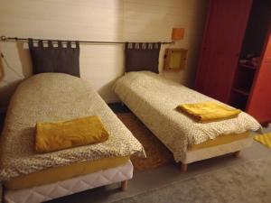 OisselにあるBungalow la Bohémienneのベッド2台が隣同士に設置された部屋です。