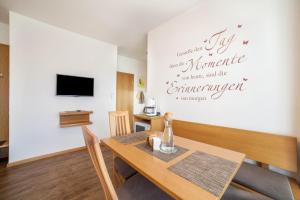 a dining room with a table and a tv at Schnitzer Ferienwohnung Löwenzahn in Rablà