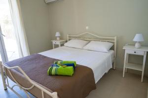 a bedroom with a bed with a green bag on it at Private Villa's in NW Corfu with Pool in Kavvadádes