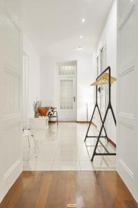 a hallway with white walls and a white floor with a sculpture at Irundo Downtown Apartments in Zagreb