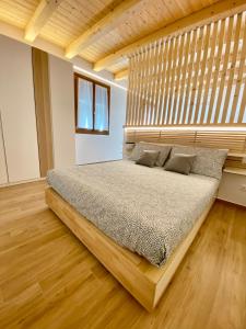 - une chambre avec un grand lit et une tête de lit en bois dans l'établissement Locanda Da Marco, à Pignone