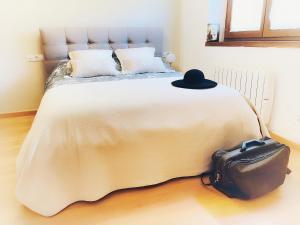 Una cama con un sombrero negro encima. en Apartamento Valle de Alba en Benasque