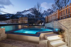 a swimming pool with mountains in the background at Garnì La Dorada in Colfosco