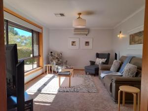 a living room with a couch and a tv at 3 Pears on the Park McLaren Vale in McLaren Vale