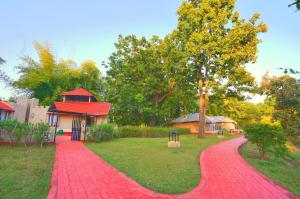 a red brick path in front of a park at Bundela Bandhavgarh by Octave in Mānpur